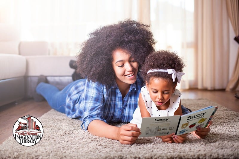 A parent and child reading an Imagination Library book together